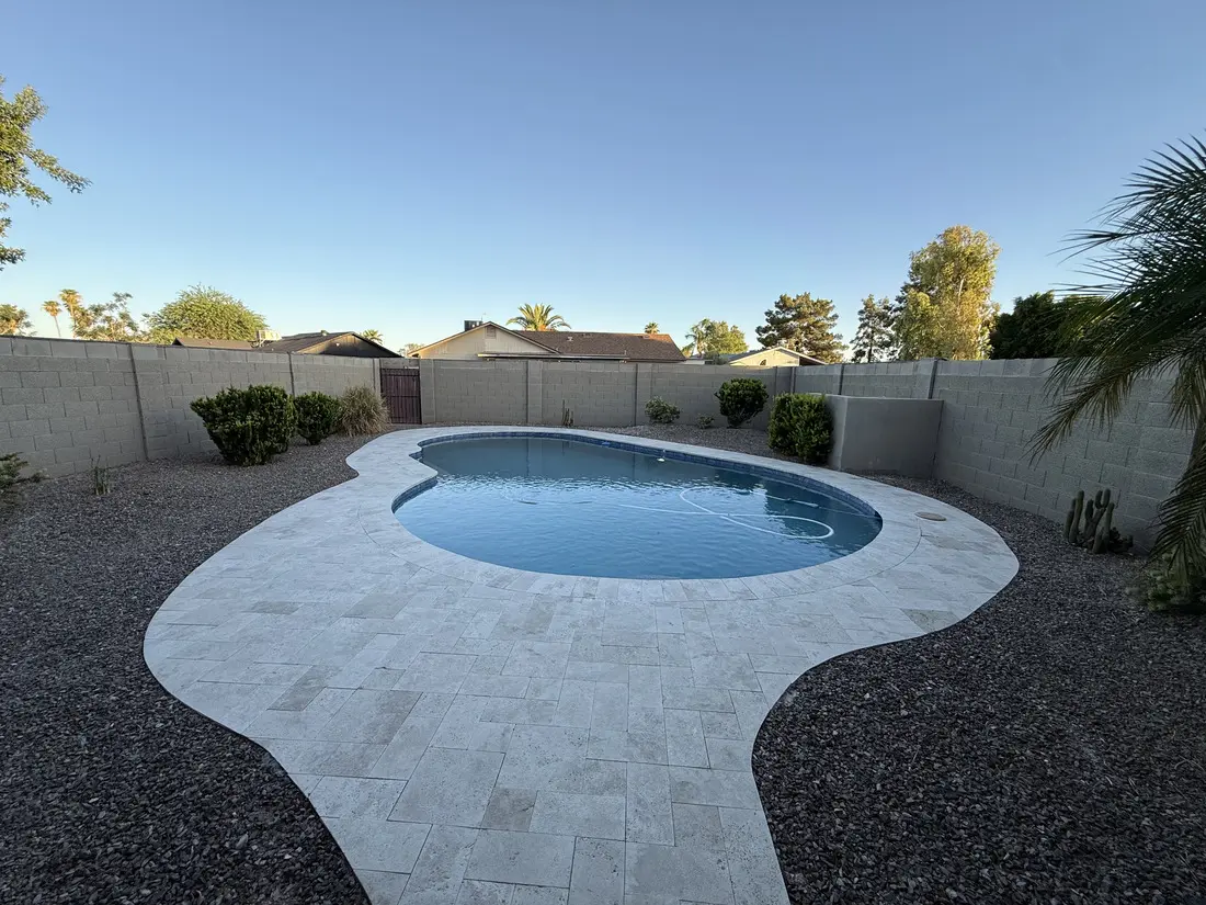 The travertine-decked pool and desert backyard